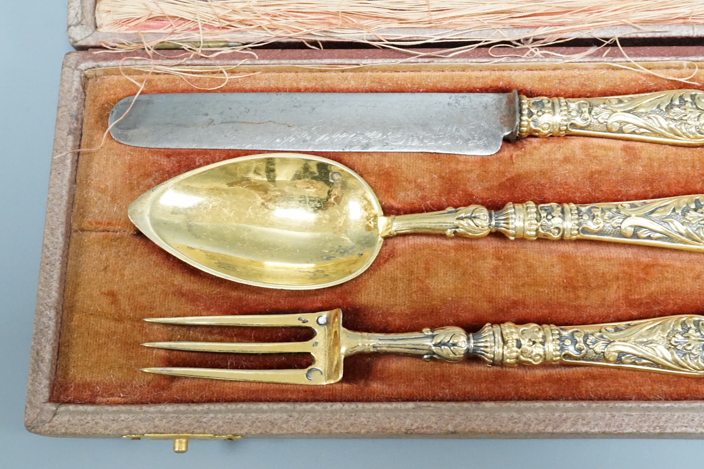 A leather cased early 19th century gilt white metal three piece cutlery set, knife 18.1cm.